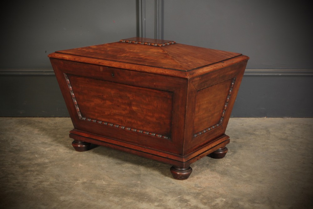 A Regency period mahogany sarcophagus cellarette featuring tapered sides, beaded moulding, and compressed turned feet. View XII