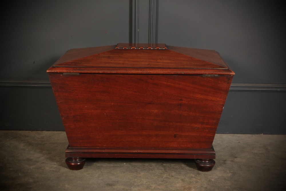 A Regency period mahogany sarcophagus cellarette featuring tapered sides, beaded moulding, and compressed turned feet. View XIII