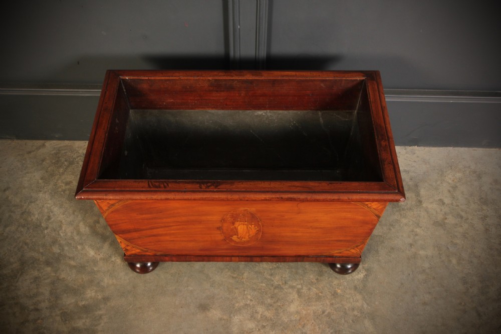 A tapered Georgian mahogany wine cooler with oval marquetry inlays raised on heavy bun feet. View II