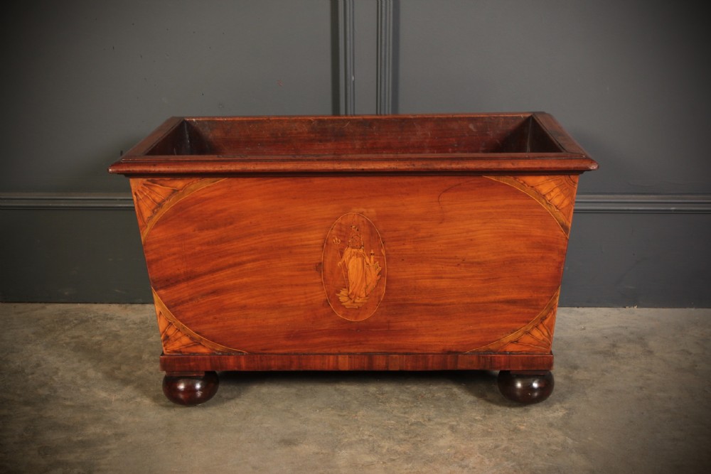 A tapered Georgian mahogany wine cooler with oval marquetry inlays raised on heavy bun feet. View III