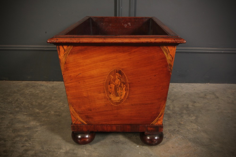 A tapered Georgian mahogany wine cooler with oval marquetry inlays raised on heavy bun feet. View VIII