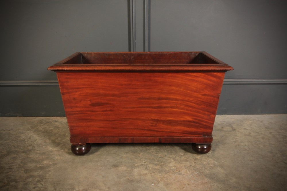 A tapered Georgian mahogany wine cooler with oval marquetry inlays raised on heavy bun feet. View IX