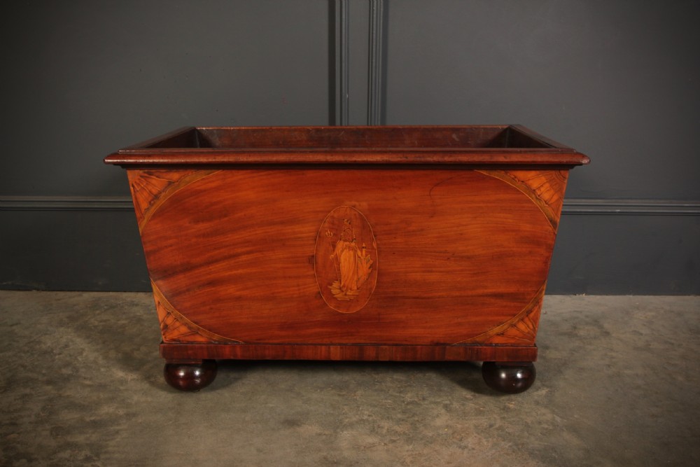 A tapered Georgian mahogany wine cooler with oval marquetry inlays raised on heavy bun feet. View XI