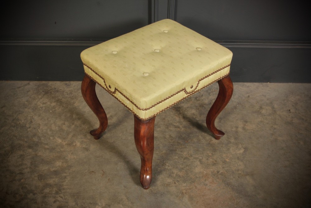 A pair of early Victorian footstools featuring dark mahogany cabriole legs and cream silk buttoned upholstered tops with brass stud detail. View III