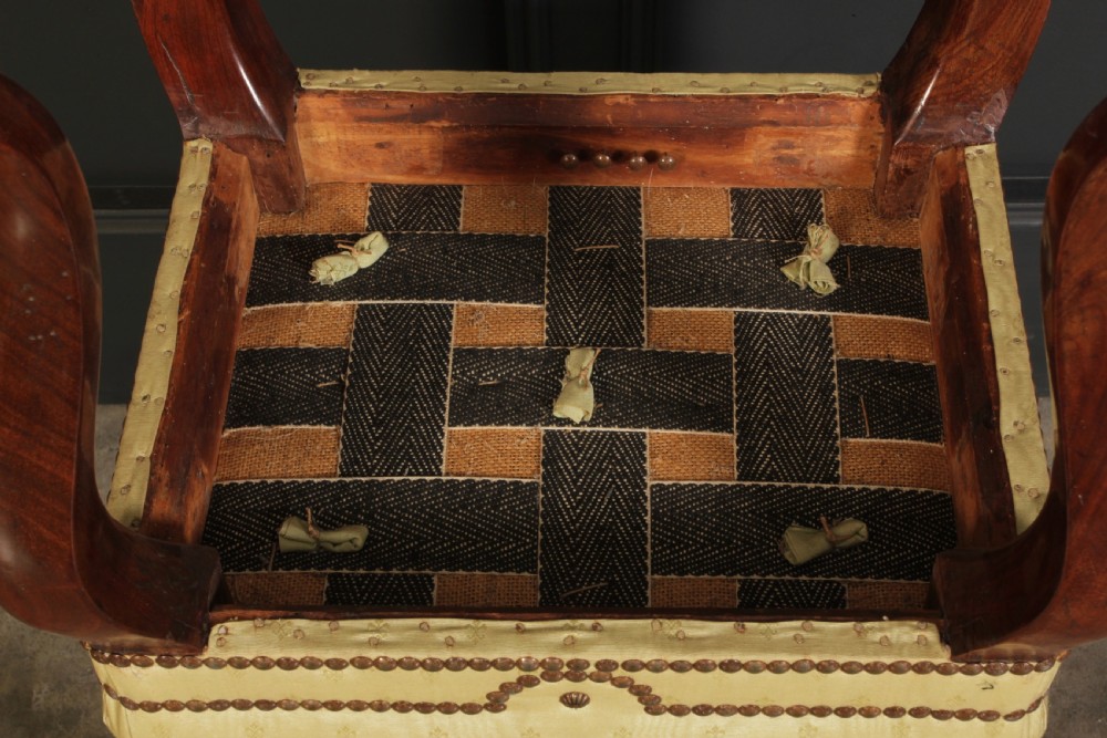 A pair of early Victorian footstools featuring dark mahogany cabriole legs and cream silk buttoned upholstered tops with brass stud detail. View X