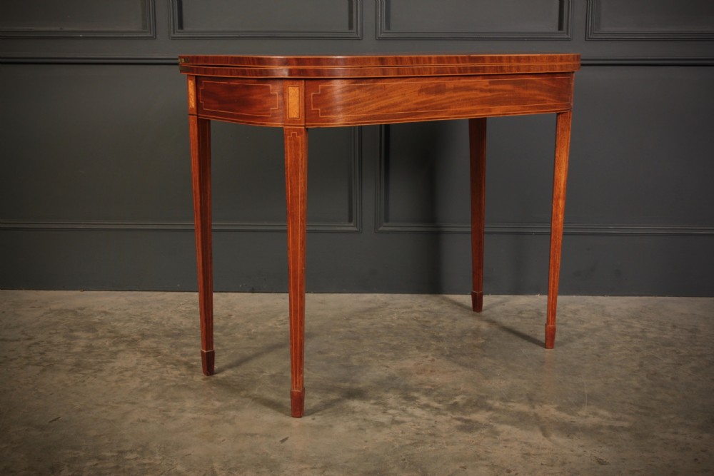 A Regency period mahogany fold-over tea table featuring boxwood line inlay, rounded front corners, and four square tapered legs. View II