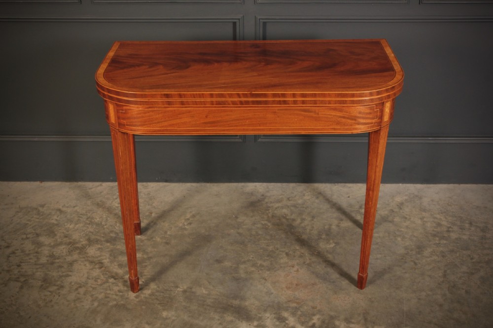 A Regency period mahogany fold-over tea table featuring boxwood line inlay, rounded front corners, and four square tapered legs. View III