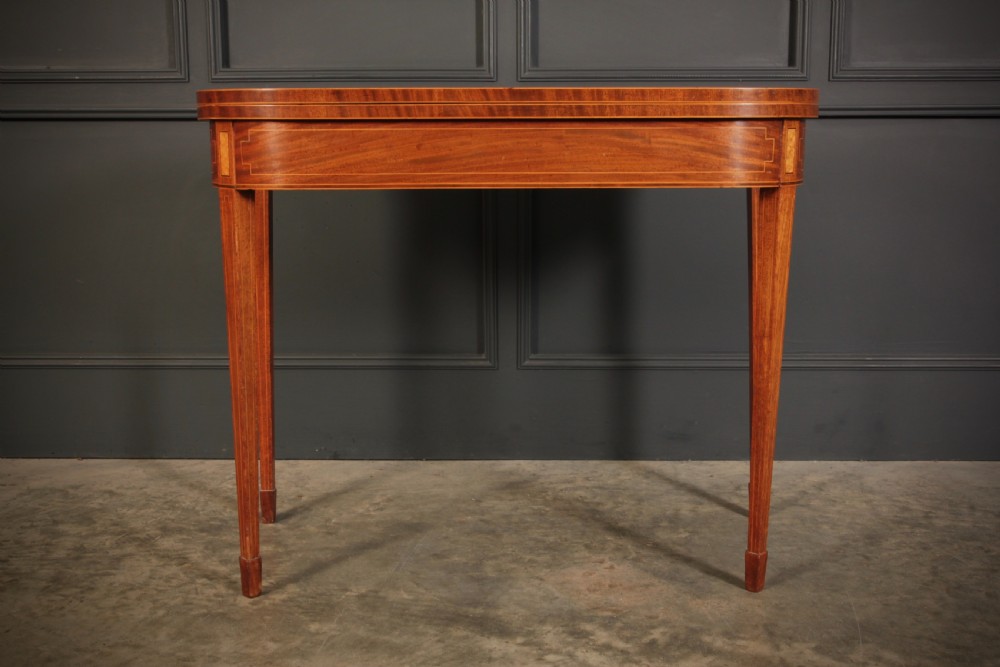 A Regency period mahogany fold-over tea table featuring boxwood line inlay, rounded front corners, and four square tapered legs. View IV