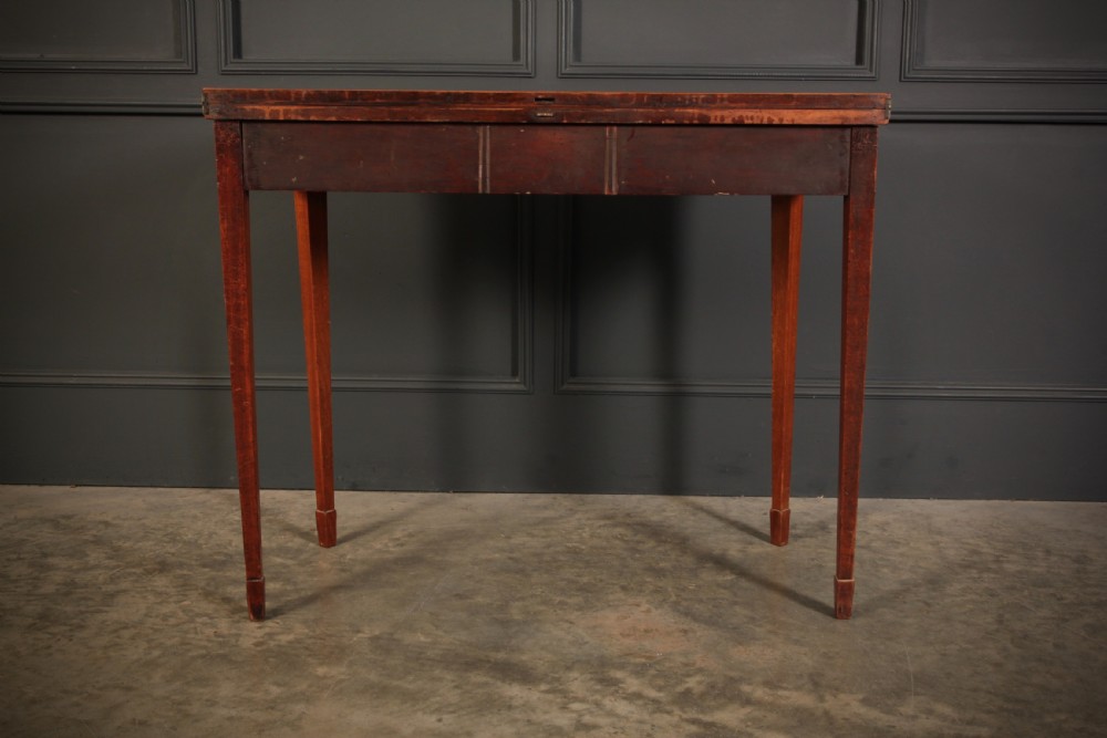 A Regency period mahogany fold-over tea table featuring boxwood line inlay, rounded front corners, and four square tapered legs. View X