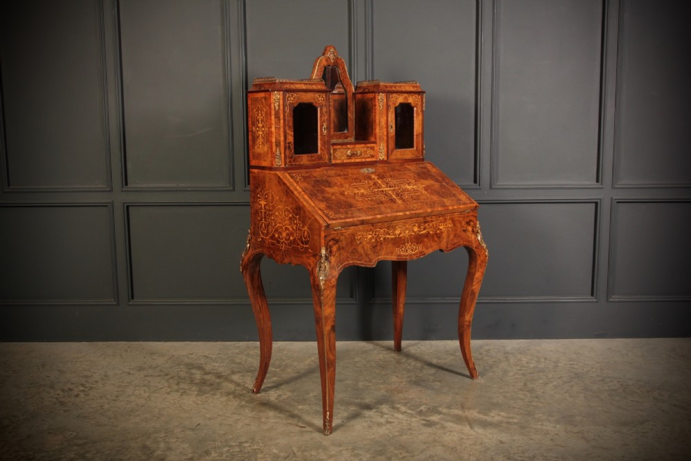 A Victorian burr walnut bonheur du jour writing desk featuring intricate floral marquetry, cabriole legs, brass mounts, and a raised superstructure with small glass cabinets. View XI