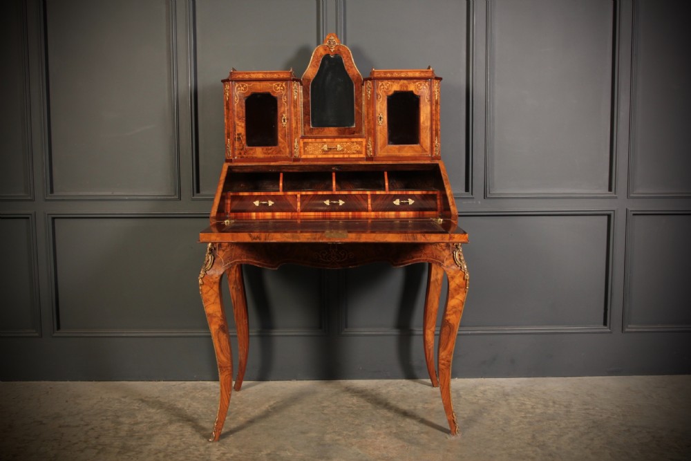A Victorian burr walnut bonheur du jour writing desk featuring intricate floral marquetry, cabriole legs, brass mounts, and a raised superstructure with small glass cabinets. View IX