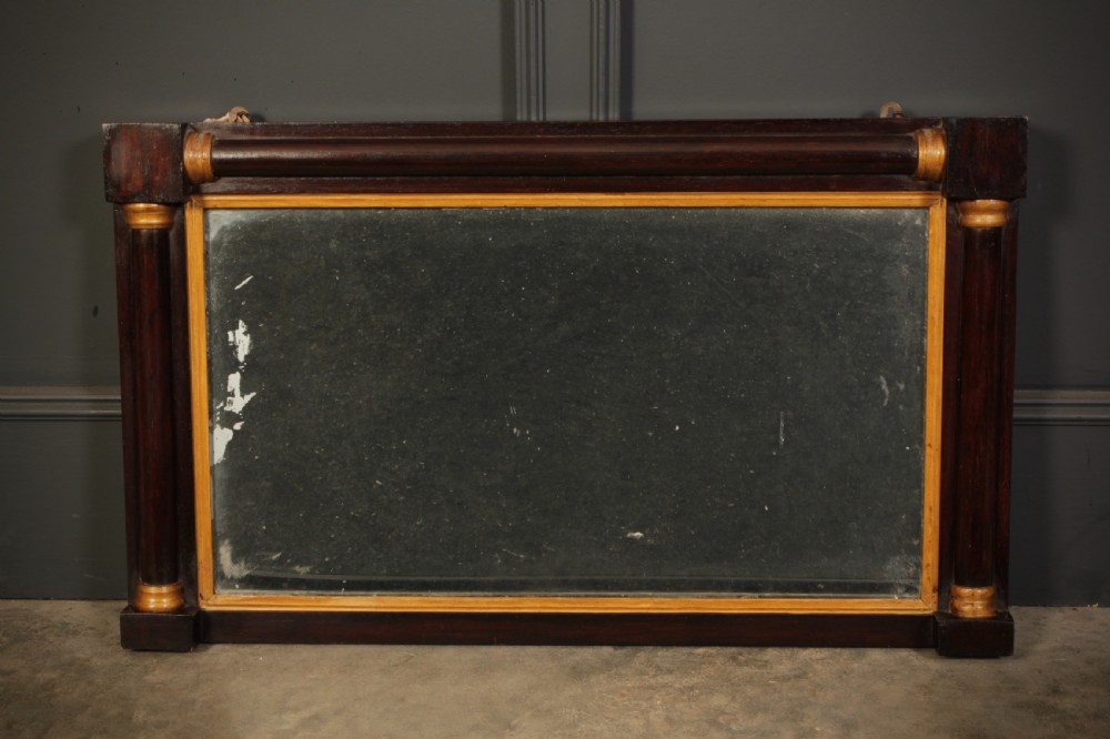 A broad rectangular antique rosewood overmantel mirror featuring pilaster side columns and a gilded inner slip moulding.