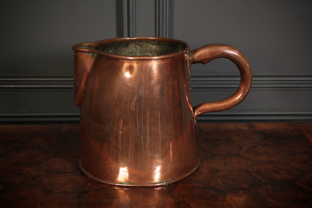 A large polished antique copper jug featuring a sturdy hollow handle, tapered body, and integrated pouring spout. View II