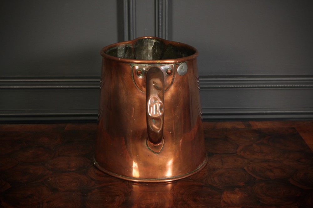 A large polished antique copper jug featuring a sturdy hollow handle, tapered body, and integrated pouring spout. View III