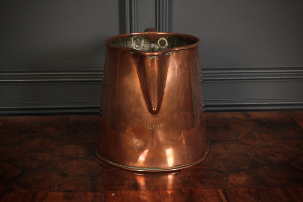 A large polished antique copper jug featuring a sturdy hollow handle, tapered body, and integrated pouring spout. View IV