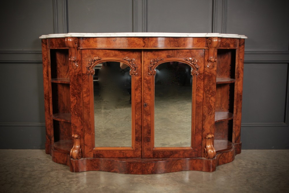 A Victorian burr walnut side cabinet featuring a white marble top, curved side shelves, and mirrored doors flanked by carved corbels. View V
