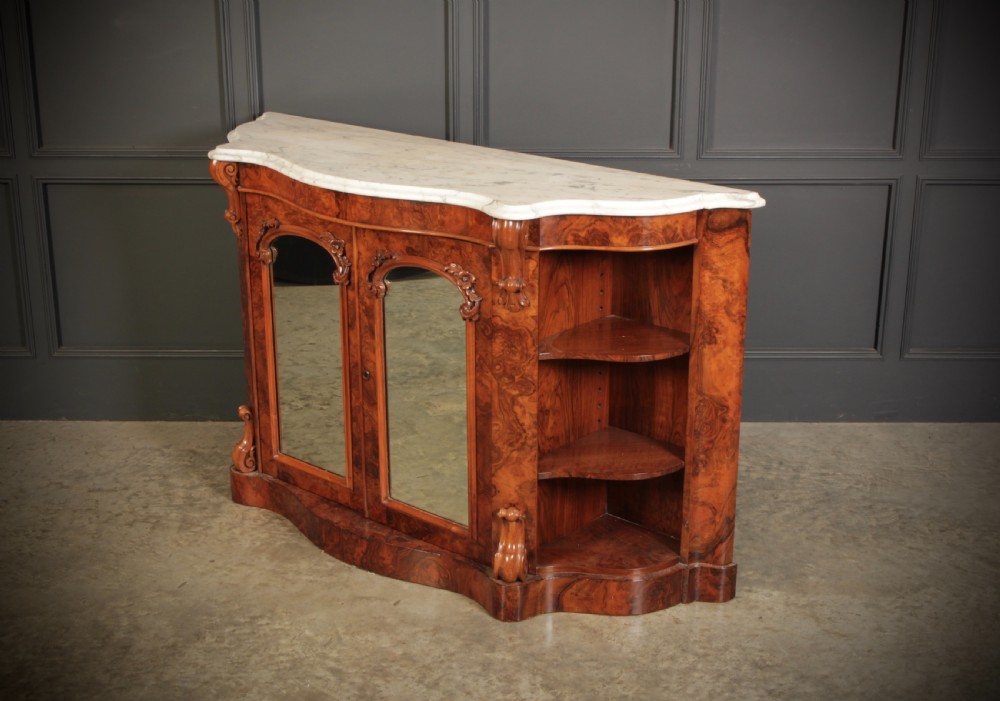 A Victorian burr walnut side cabinet featuring a white marble top, curved side shelves, and mirrored doors flanked by carved corbels. View IX