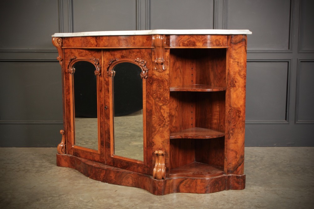 A Victorian burr walnut side cabinet featuring a white marble top, curved side shelves, and mirrored doors flanked by carved corbels. View X