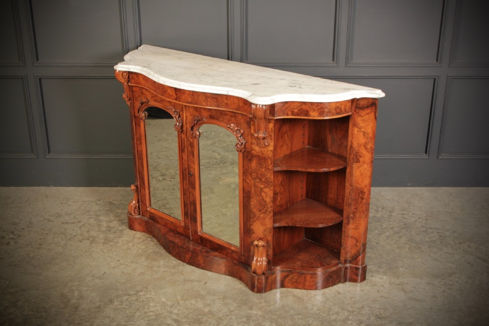 A Victorian burr walnut side cabinet featuring a white marble top, curved side shelves, and mirrored doors flanked by carved corbels. View XI