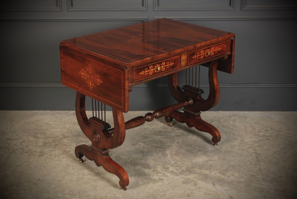 An antique dark brown rosewood sofa table featuring floral marquetry inlay, two drop leaves, twin drawers, and lyre trestle supports.