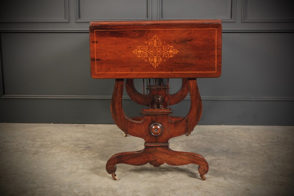 An antique dark brown rosewood sofa table featuring floral marquetry inlay, two drop leaves, twin drawers, and lyre trestle supports. View XVI