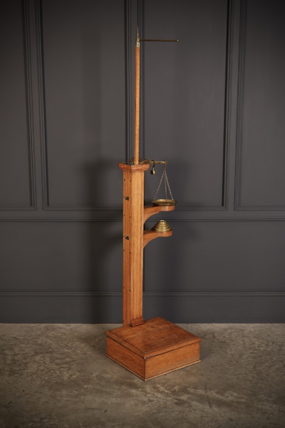 Victorian floor-standing personal weighing scales crafted from oak with brass fittings, balance arm, pan, stacked weights, and a wooden base platform. View II