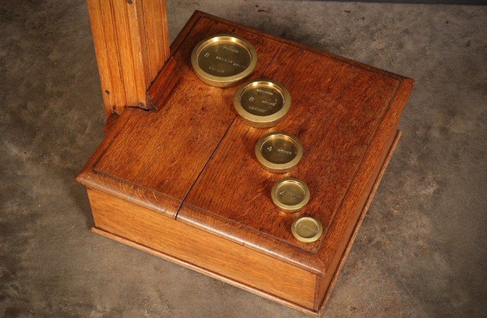 Victorian floor-standing personal weighing scales crafted from oak with brass fittings, balance arm, pan, stacked weights, and a wooden base platform. View XIII
