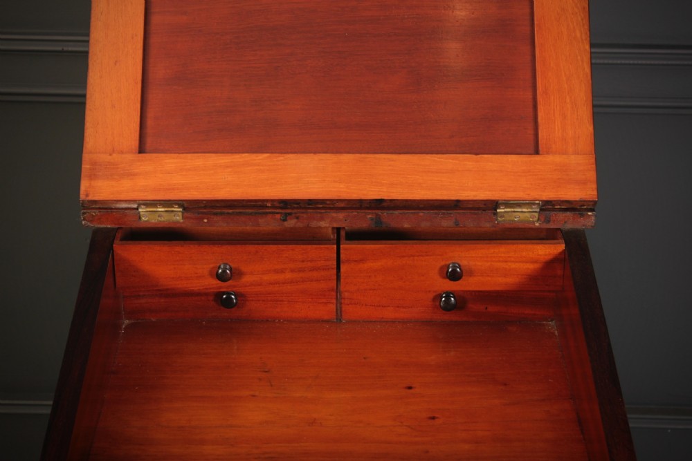 A William IV rosewood Davenport desk featuring a green leather sloped writing surface, side drawers with wooden knob handles, and turned feet on brass castors. View VI