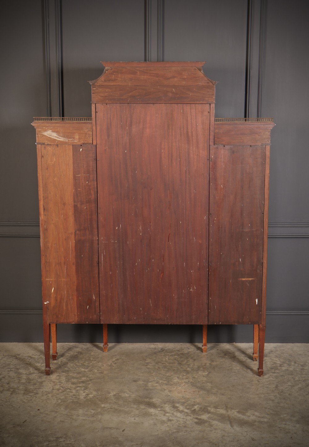 An Edwardian mahogany side cabinet with a central door featuring an urn marquetry inlay, flanked by two curved glazed display sections on tapered legs. View X