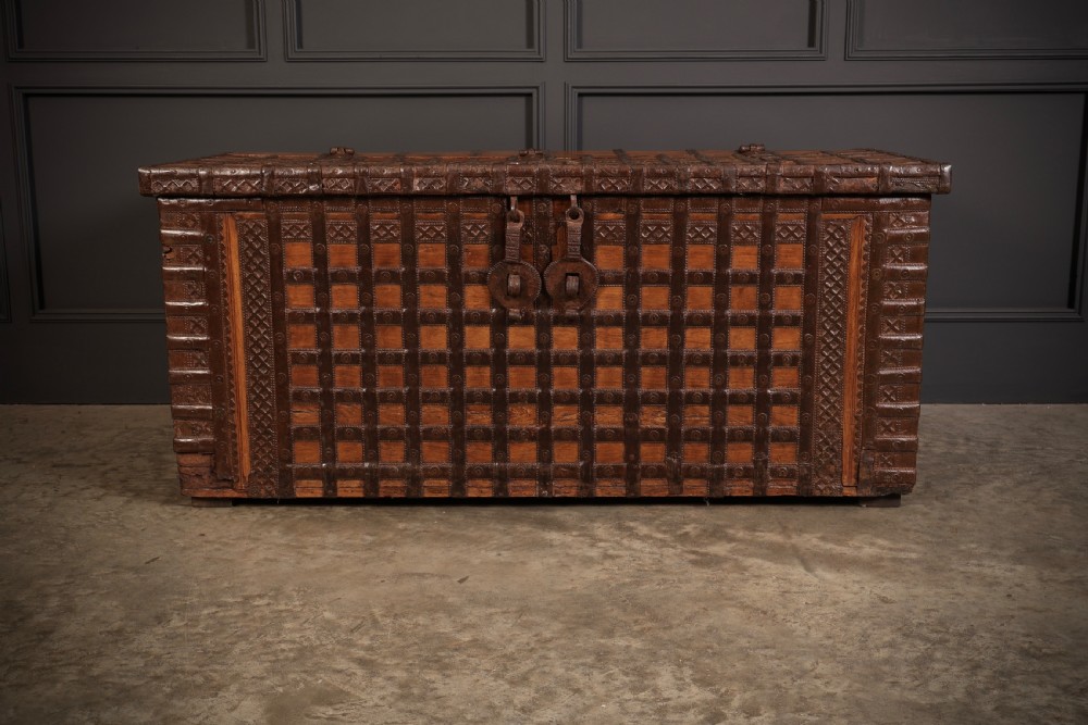 A large rectangular brown hardwood trunk reinforced with a grid of iron straps and featuring heavy iron latches on the front. View V
