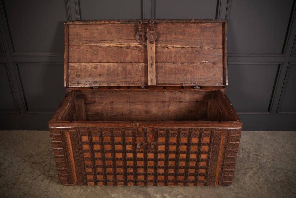 A large rectangular brown hardwood trunk reinforced with a grid of iron straps and featuring heavy iron latches on the front. View VI
