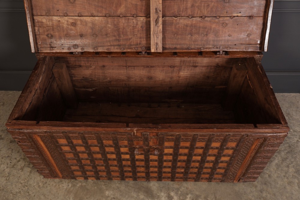A large rectangular brown hardwood trunk reinforced with a grid of iron straps and featuring heavy iron latches on the front. View VII