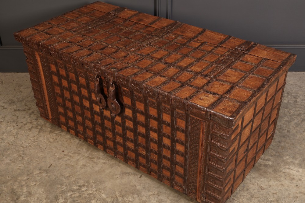 A large rectangular brown hardwood trunk reinforced with a grid of iron straps and featuring heavy iron latches on the front. View IX