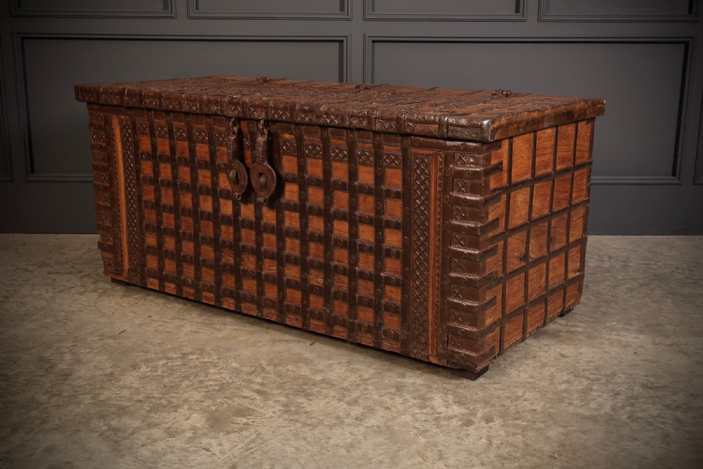 A large rectangular brown hardwood trunk reinforced with a grid of iron straps and featuring heavy iron latches on the front. View XI