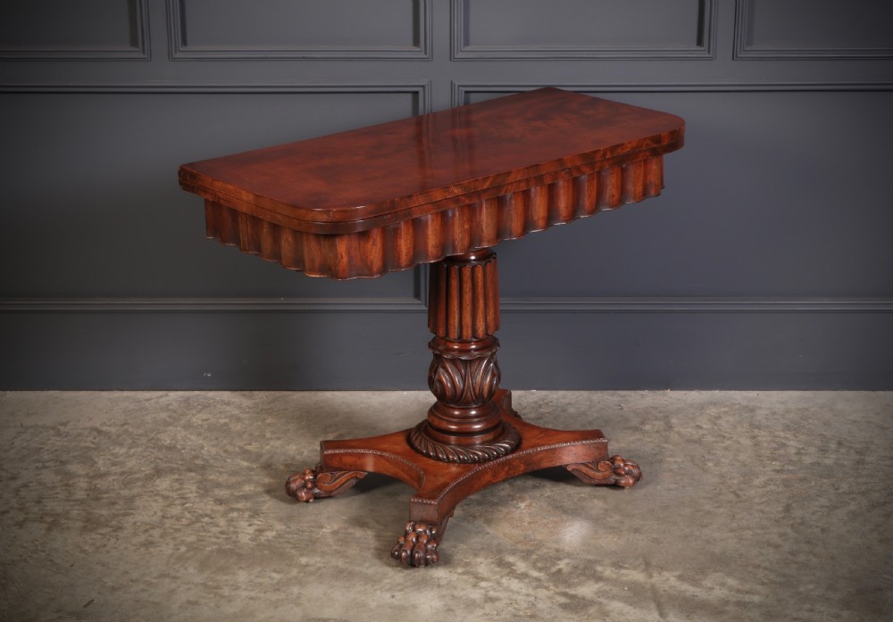 A Regency mahogany card table featuring a fold-over rectangular top, reeded apron, carved central pedestal, and quadripartite base with paw feet. View XII