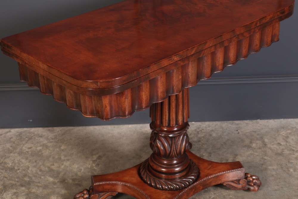 A Regency mahogany card table featuring a fold-over rectangular top, reeded apron, carved central pedestal, and quadripartite base with paw feet. View III