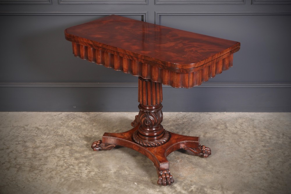 A Regency mahogany card table featuring a fold-over rectangular top, reeded apron, carved central pedestal, and quadripartite base with paw feet. View V