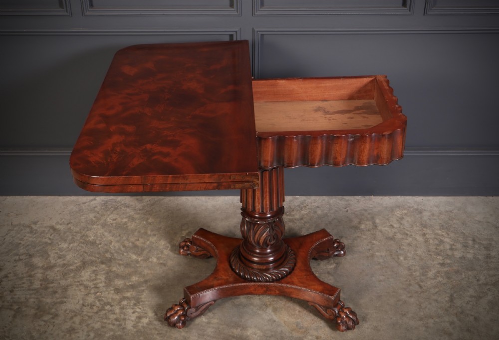 A Regency mahogany card table featuring a fold-over rectangular top, reeded apron, carved central pedestal, and quadripartite base with paw feet. View X