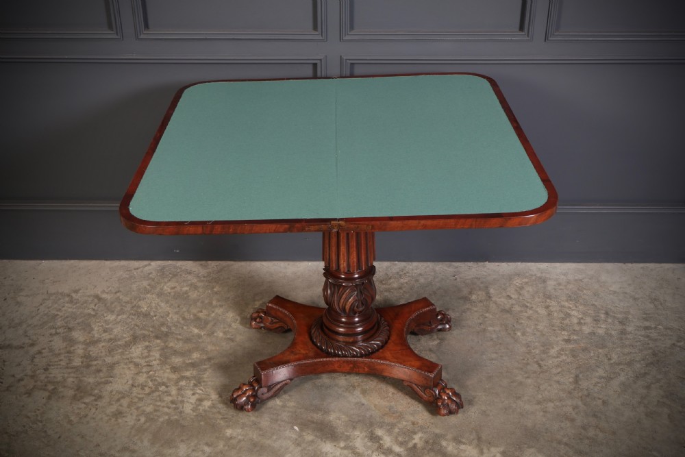 A Regency mahogany card table featuring a fold-over rectangular top, reeded apron, carved central pedestal, and quadripartite base with paw feet. View XI