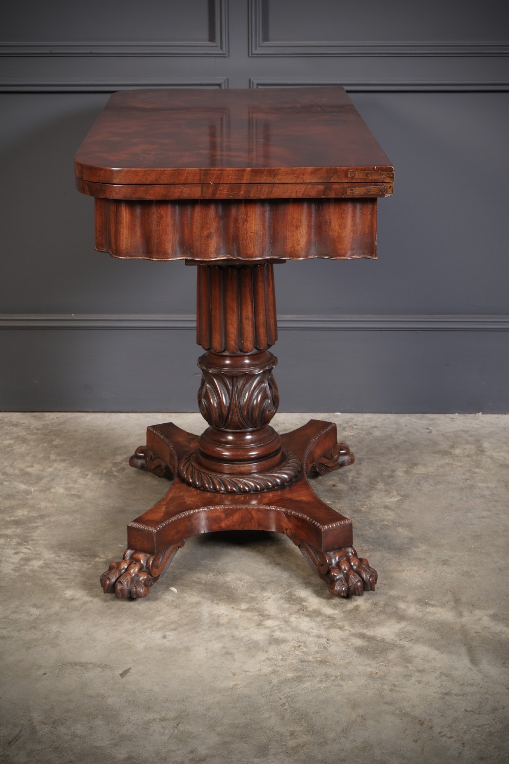 A Regency mahogany card table featuring a fold-over rectangular top, reeded apron, carved central pedestal, and quadripartite base with paw feet. View XIII