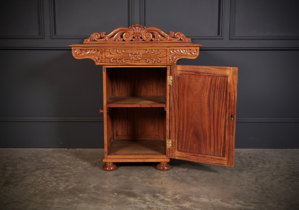 A carved satinwood Anglo-Indian side cabinet featuring a scroll-carved gallery back, panelled door, and turned feet. View VI