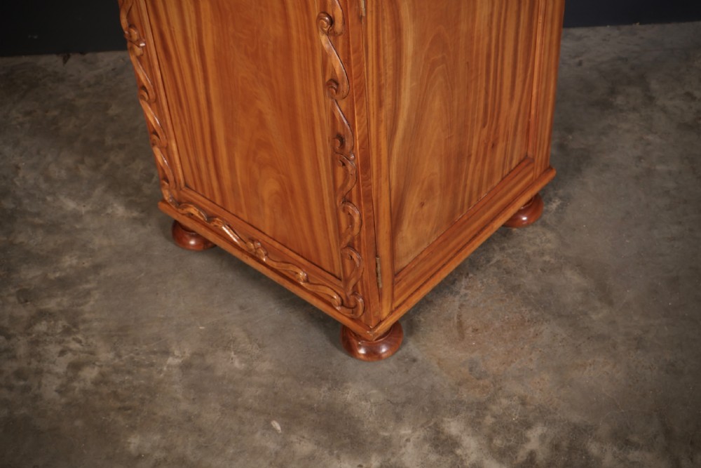 A carved satinwood Anglo-Indian side cabinet featuring a scroll-carved gallery back, panelled door, and turned feet. View X