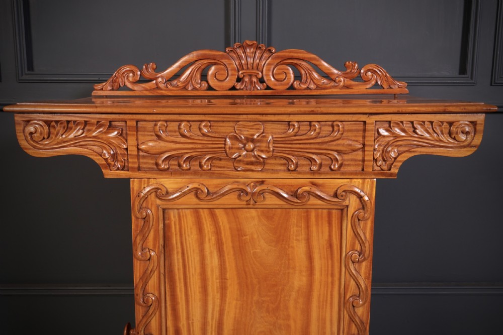 A carved satinwood Anglo-Indian side cabinet featuring a scroll-carved gallery back, panelled door, and turned feet. View XII