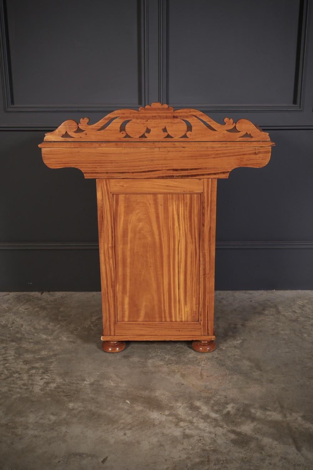 A carved satinwood Anglo-Indian side cabinet featuring a scroll-carved gallery back, panelled door, and turned feet. View XIV
