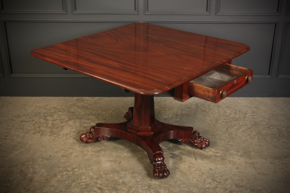 A William IV dark mahogany Pembroke table featuring two drop-down leaves, a single drawer with turned wooden knobs, a central pedestal, and a four-pointed base ending in carved claw feet. View III