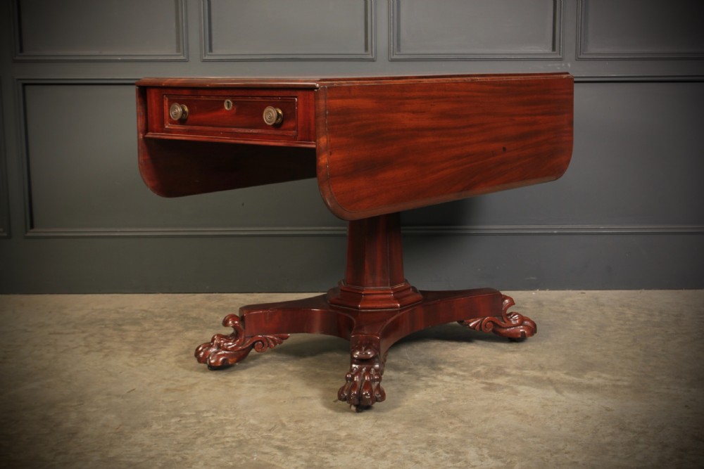 A William IV dark mahogany Pembroke table featuring two drop-down leaves, a single drawer with turned wooden knobs, a central pedestal, and a four-pointed base ending in carved claw feet. View X
