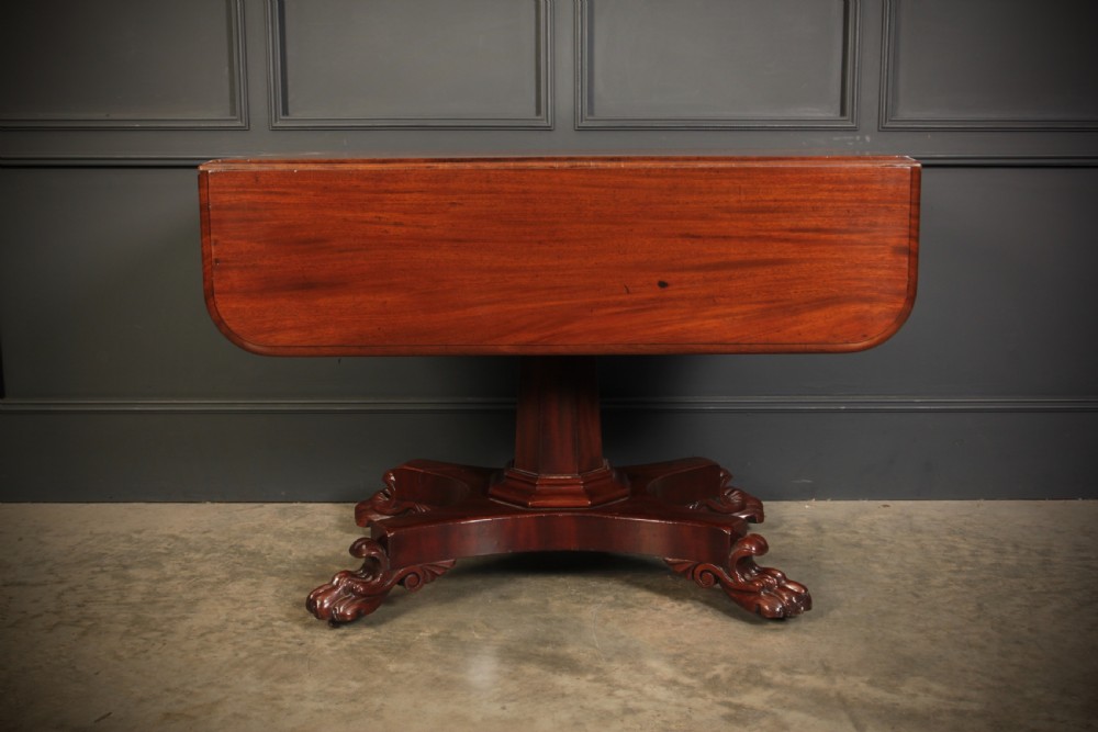 A William IV dark mahogany Pembroke table featuring two drop-down leaves, a single drawer with turned wooden knobs, a central pedestal, and a four-pointed base ending in carved claw feet. View XI