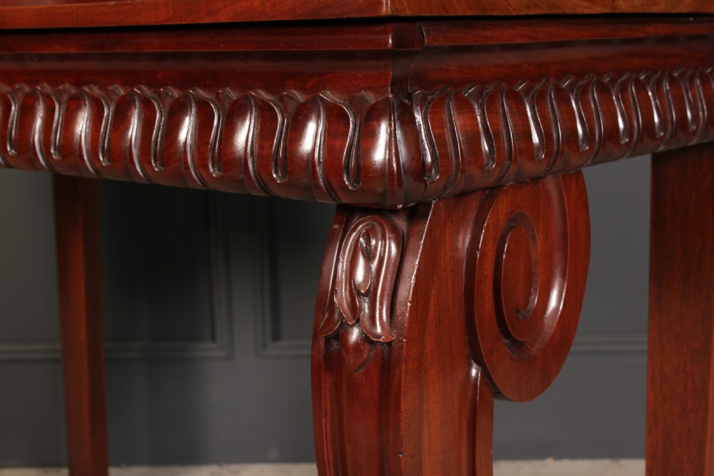 A William IV mahogany console table featuring a raised gallery back, gadrooned edge detailing, and bold S-scroll front legs on brass castors. View XII