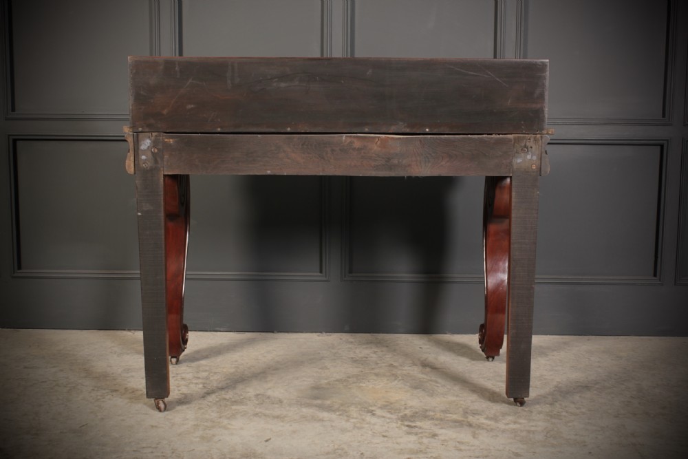 A William IV mahogany console table featuring a raised gallery back, gadrooned edge detailing, and bold S-scroll front legs on brass castors. View XVII