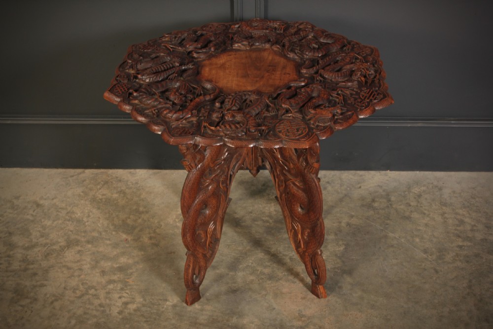 An octagonal dark hardwood occasional table featuring deep relief dragon carvings across the tabletop and legs. View II